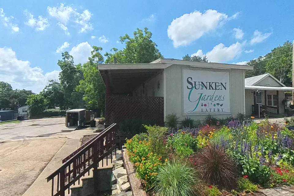 A dewarped 360 frame of the Sunken Gardens sign, front planting bed, steps, stonework, and parking edge during the May 25 property audit.