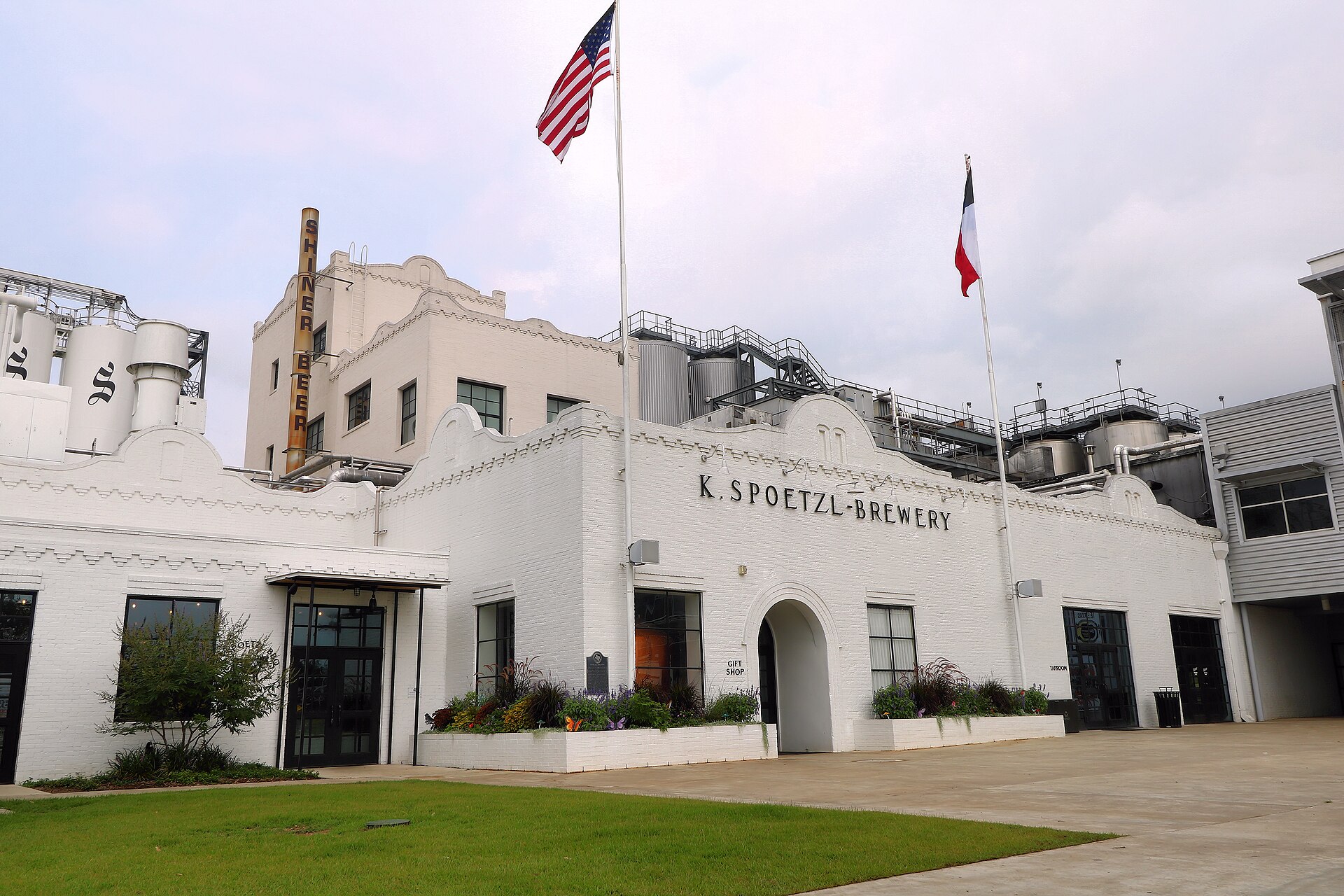 Exterior of the Spoetzl Brewery in Shiner, Texas, a low brick building with brewery signage.