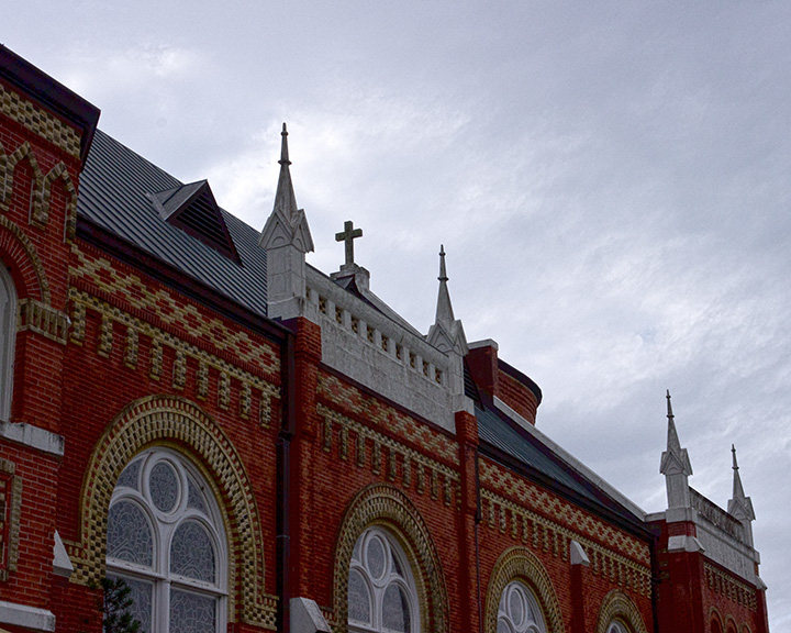 The roof and exterior of Saints Cyril and Methodius Catholic Church in Shiner, Texas, viewed from across the road.